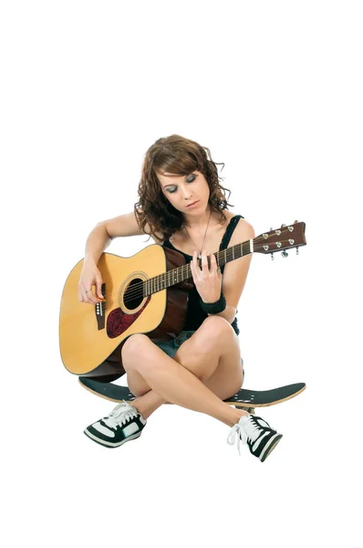 Vacker ung brunett ler när hon spelar gitarr. — Stockfoto