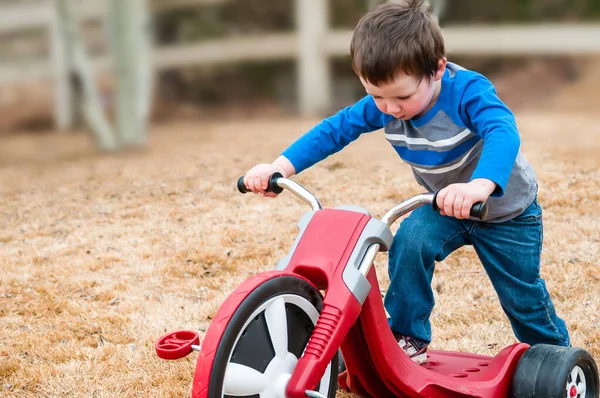 Petit garçon avec un tricycle dans l'air frais de l'automne — Photo