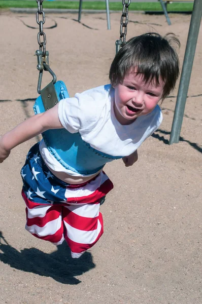 Netter kleiner Junge zu kurz, um in den größeren Schaukeln zu sitzen — Stockfoto