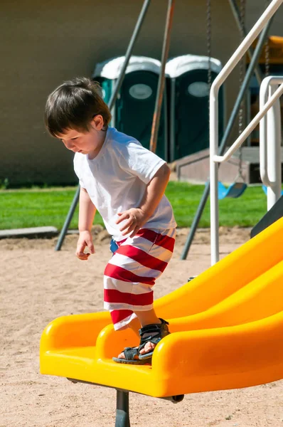 町の公園で彼の日を楽しんでいる小さな男の子 — ストック写真