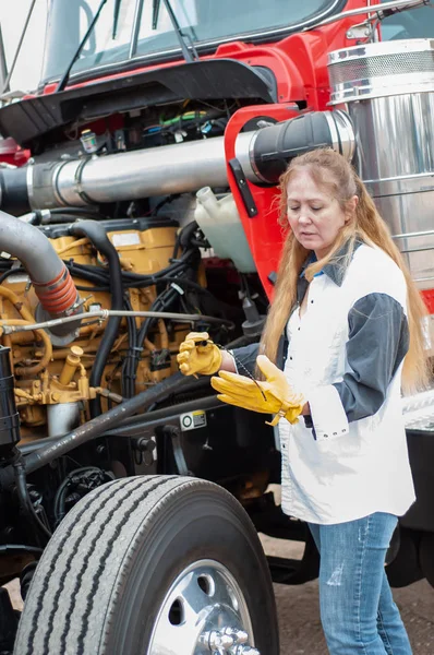 Femme chauffeur de camion vérifiant le niveau d'huile sur un gros camion — Photo