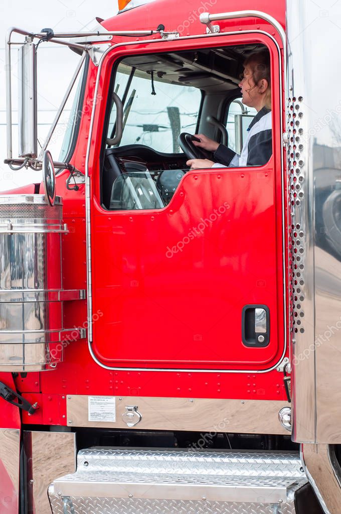 Woman Truck Driver looking out the windshield while driving a big rig
