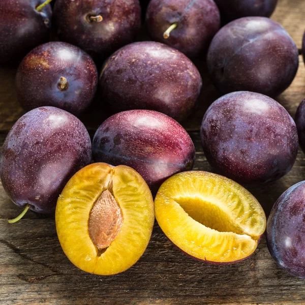 Fresh blue plums on wooden table Stock Photo