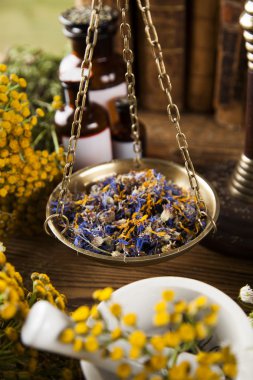 Ahşap masa üzerinde kitap ve bitkisel tıp