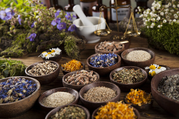 Травы и раствор на деревянном столе
