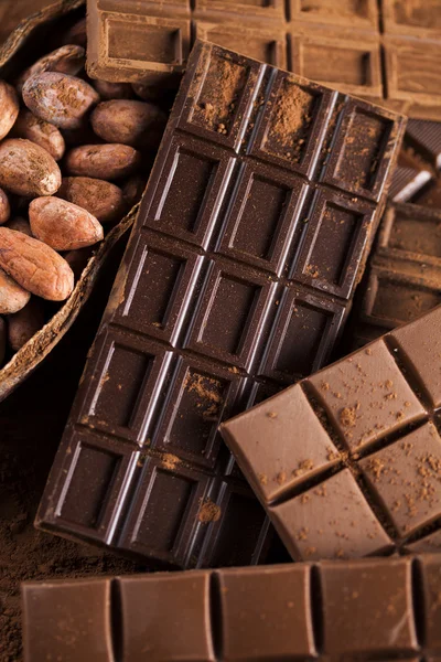 Barras de chocolate con granos de cacao y polvo — Foto de Stock