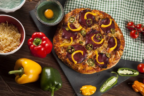 Pizza e ingredienti in tavola — Foto Stock