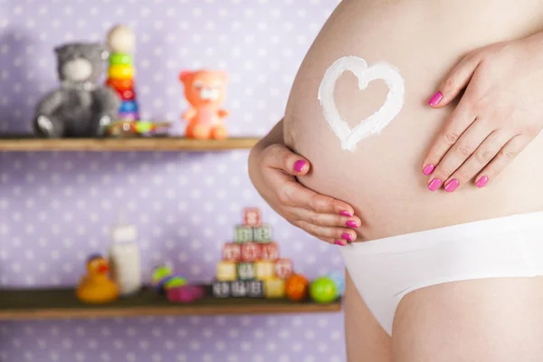 Pregnant woman with heart sign — Stock Photo, Image