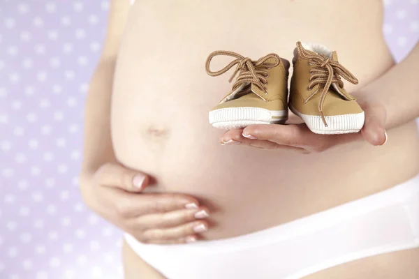 Schwangere mit Babyschuhen — Stockfoto