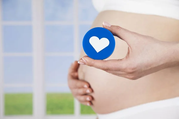 Pregnant woman with heart sign