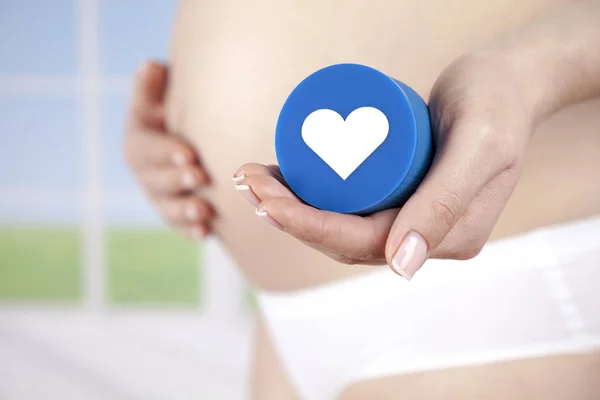 Pregnant woman with heart sign