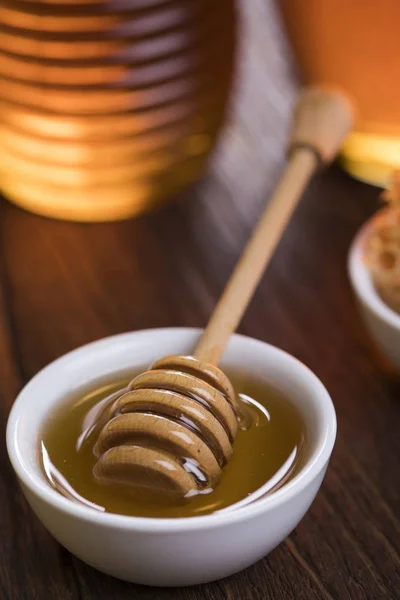 Honey jar with dipper and flowing honey — Stock Photo, Image