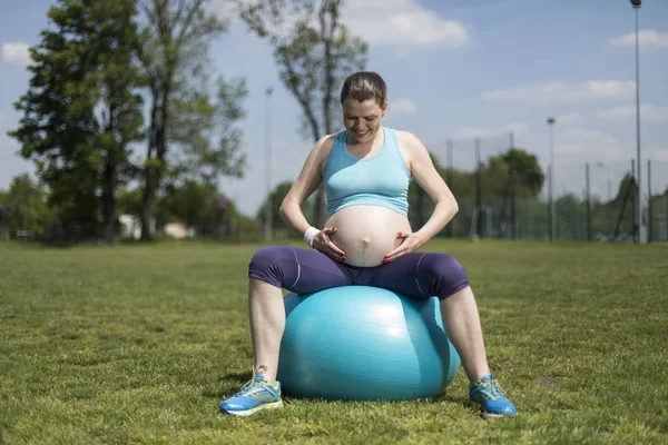 Όμορφη νεαρή έγκυος γυναίκα ασκήσεις με fitball στο γυμναστήριο — Φωτογραφία Αρχείου