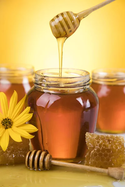 Honey and wooden stick are on a table — Stock Photo, Image