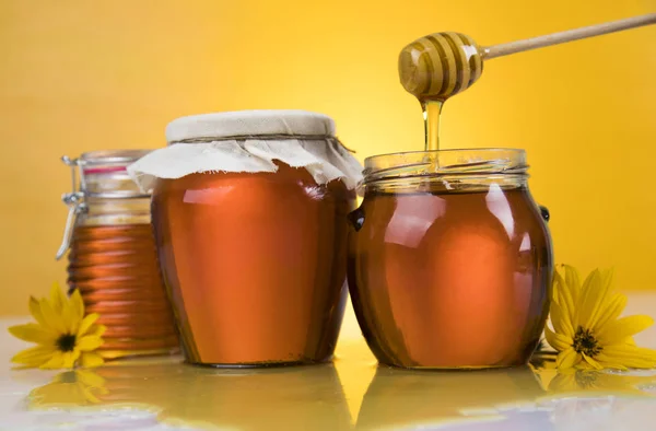 Med a dřevěnou tyčí jsou na stole — Stock fotografie