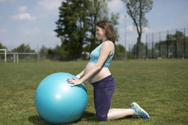 Těhotná žena, která dělá fitness cvičení — Stock fotografie