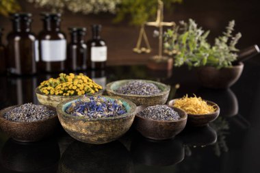 Alternatif sağlık, taze bitkisel ve havan topları siyah aynada.