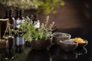 Alternatif sağlık, taze bitkisel ve havan topları siyah aynada.