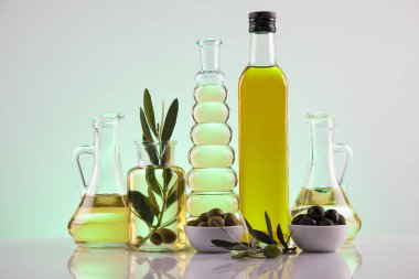 İçinde organik zeytinyağı ve zeytin dalı olan şişeler.