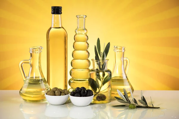 Butelki oliwy z oliwek, gałąź oliwna i oleje do gotowania — Zdjęcie stockowe