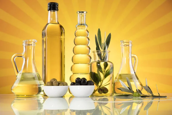Flessen met biologische bakolie en olijftak — Stockfoto