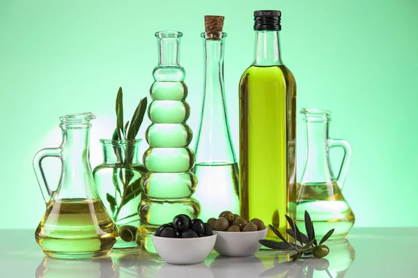 Botellas con aceite de oliva ecológico y rama de olivo — Foto de Stock