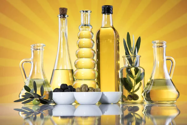 Bottles with organic cooking olive oil and olive branch — Stock Photo, Image