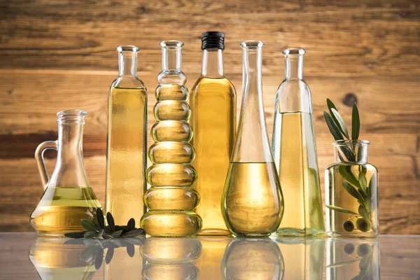 Butelki oliwy z oliwek, gałąź oliwna i oleje do gotowania — Zdjęcie stockowe