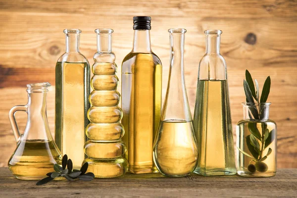 Bottles with organic cooking olive oil and olive branch — Stock Photo, Image