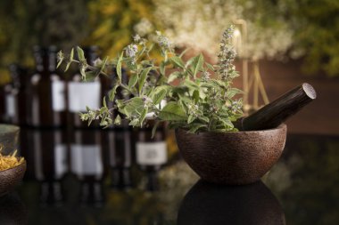 Alternatif sağlık, taze bitkisel ve havan topları siyah aynada.