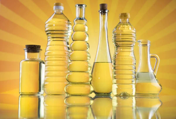 Rapeseed oil, sunflower oil, olive oil on sunburst orange backgr — ストック写真