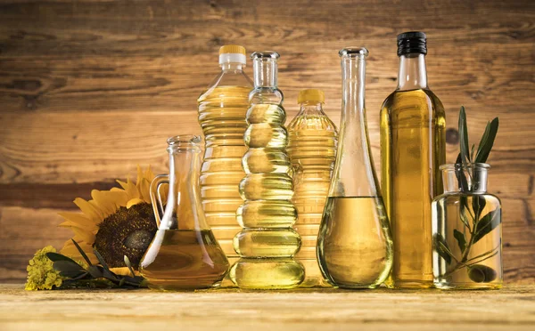 Bottiglie di olio d'oliva, ramo d'oliva e oli da cucina — Foto Stock