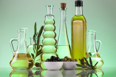 Zeytin yağı şişeleri, zeytin dalı ve pişirme yağları.