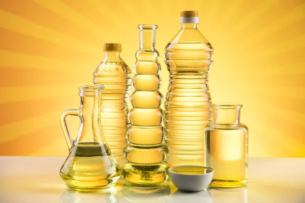 Olive oil, rapeseed oil, sunflower oil on sunburst orange background