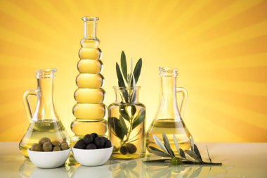 Zeytin yağı şişeleri, zeytin dalı ve pişirme yağları.