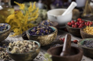 Homeopati, ahşap masada bitkisel ilaçlar.