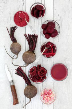 Pancar gıda ile dilimlenmiş, güler yüzlü suyu içecek, taze, tozu, turşu ve rendelenmiş beetroots rustik ahşap zemin üzerine sağlık ve süper. Tıbbi özellikleri vardır ve Antosiyaninler, vitaminler ve antioksidanlar içerir.