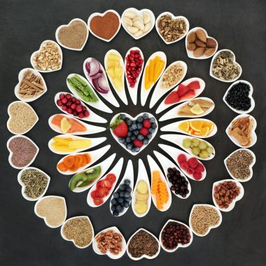 Health food collection on slate with fish, fruit, vegetables, nuts, seeds, cereals, grains with herbs and spices used in herbal medicine for heart health. Superfood concept high in omega 3, antioxidants and vitamins. clipart