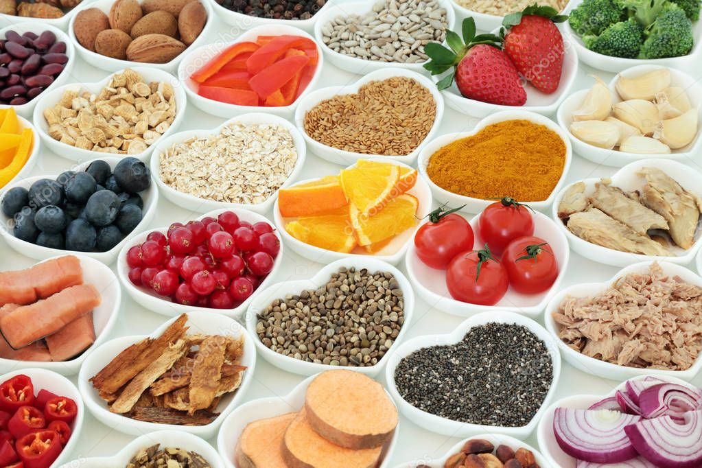 Healthy lifestyle super food concept with fresh fruit, vegetables, fish, seeds, nuts, cereals, herbs and spices with medicinal herbs. Foods high in antioxidants, anthocyanins, vitamins, minerals and fiber.