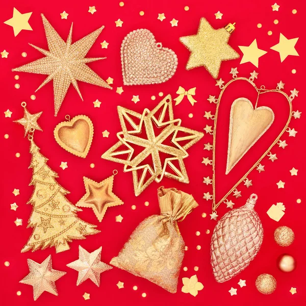 Zlaté vánoční ozdoby stromků na červeném pozadí — Stock fotografie