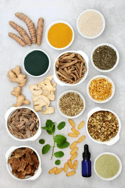 Herbs & spices used in chinese herbal medicine to treat irritable bowel syndrome with dietary supplement powders, aromatherapy essential oil & vitamin capsules. Flat lay.