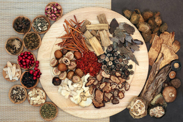 Chinese  herbs & spice used in traditional herbal medicine on a wooden board, bamboo & lokta paper. Flat lay