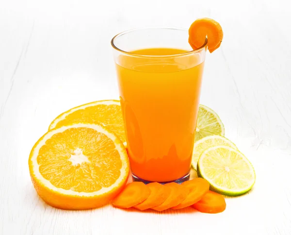 Стаканы сока с морковью, апельсином и лимоном — стоковое фото