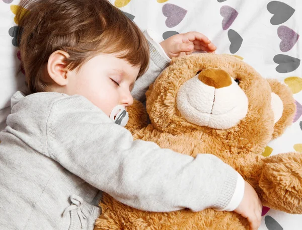 Child sleeping with teddy bear — Stock fotografie