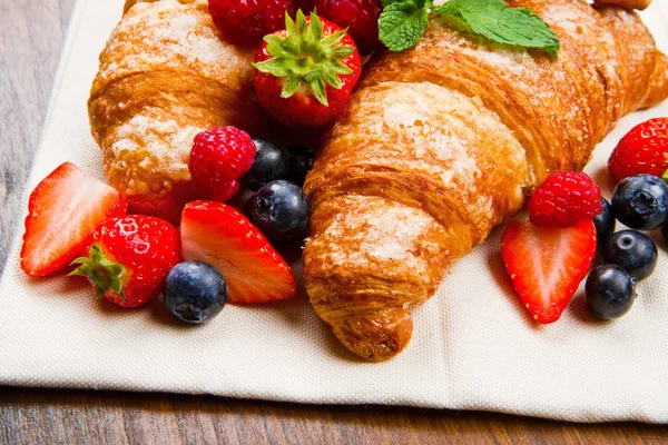 Fresh tasty croissants with berries — Stock Photo, Image