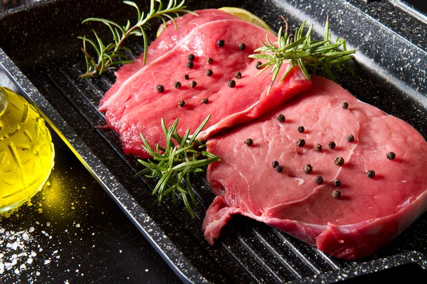 Carne crua em fatias no pote da placa no fundo preto — Fotografia de Stock