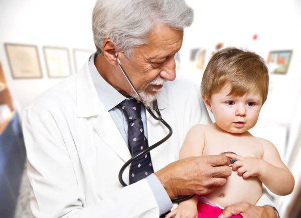 Médico masculino examinando uma criança paciente — Fotografia de Stock
