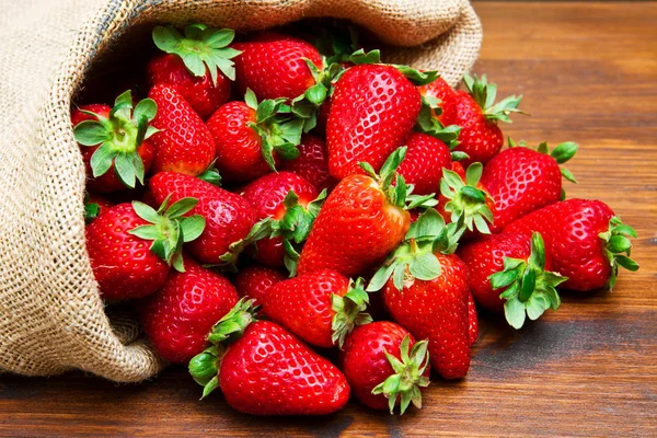 Fresh strawberries in burlap sack — Stock Photo, Image
