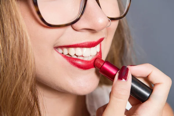 Sorridente ragazza mettere il rossetto sulle labbra — Foto Stock