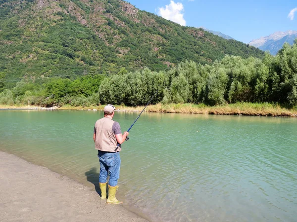 Мужчина ловит рыбу на берегу — стоковое фото